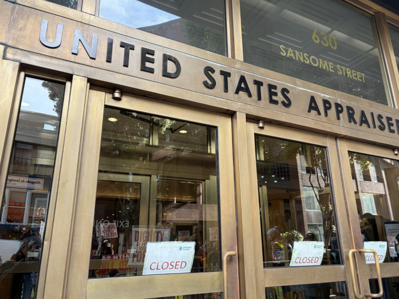 Exterior of a United States Appraiser building at 630 Sansome Street, showing glass doors with multiple "Closed" signs posted—possibly indicating a recent scam alert or security concern.