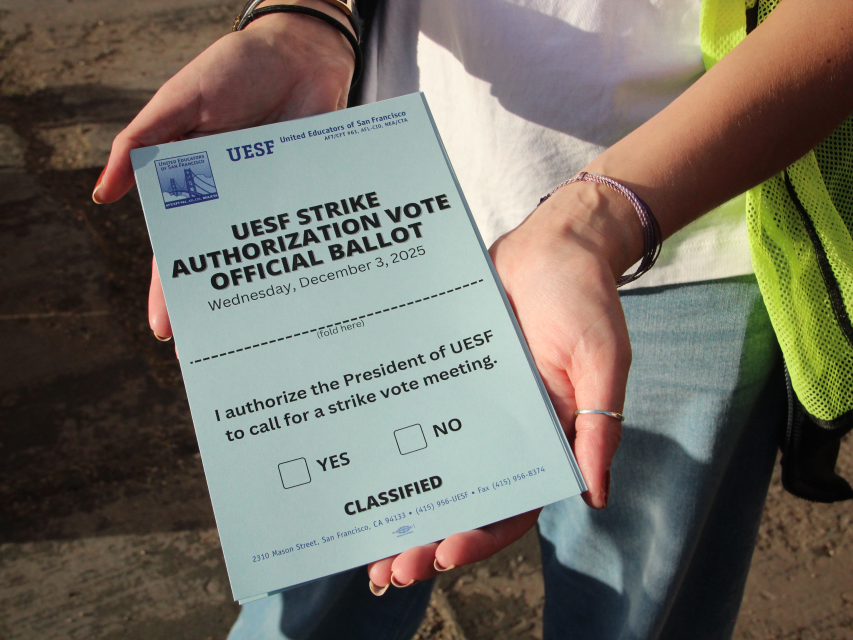 A person holds a UESF Strike Authorization Vote Official Ballot dated December 3, 2025, with checkboxes for “Yes” and “No” authorizing a strike vote meeting.