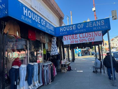 Clothing store called House of Jeans with a large "Store Closing 20 to 50% Off" banner; jeans and dresses displayed outside on racks and mannequins.