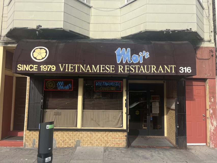 The storefront of Mai’s Vietnamese Restaurant displays a dark awning with the restaurant’s name, a neon sign, and the address number 316.