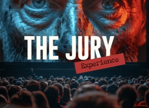 An audience sits in a theater facing a large screen displaying a close-up face with text reading "THE JURY Experience.