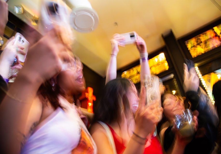A group of people holding up their phones.