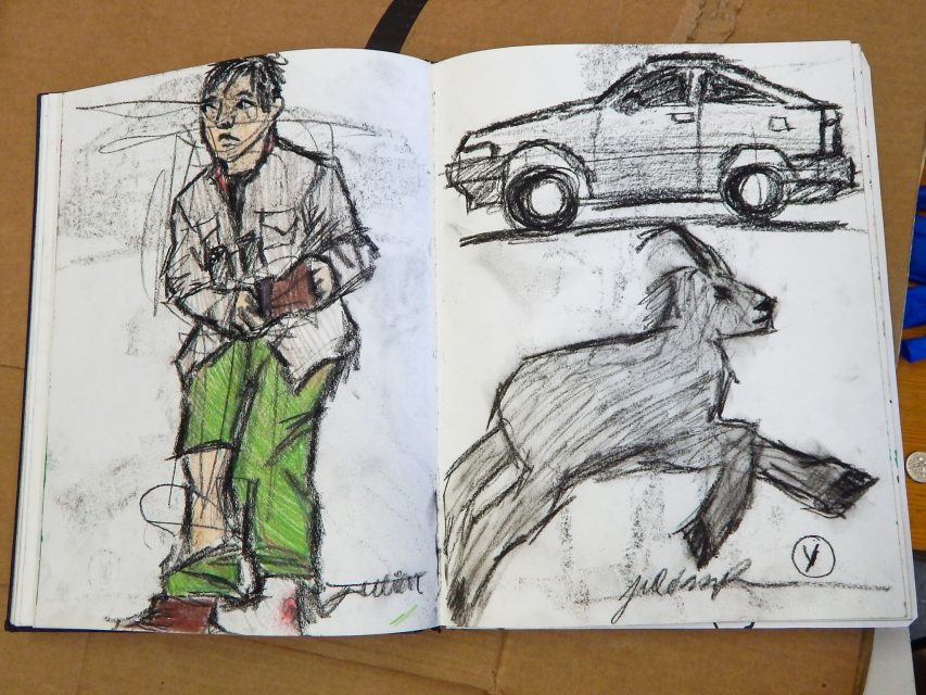 A sketchbook open to pages showing three charcoal drawings: a person in green pants, a side view of a car, and a goat in mid-leap.