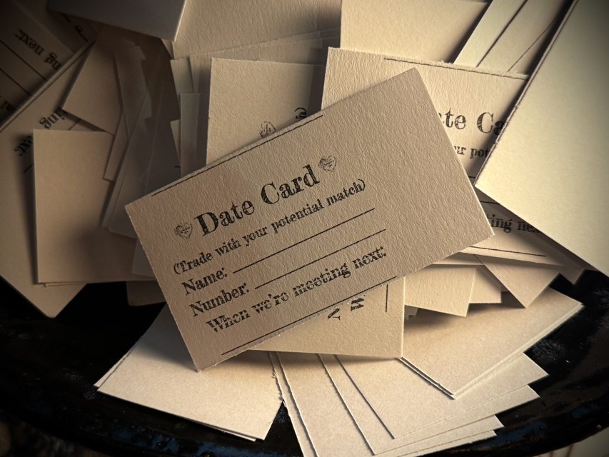 A stack of blank "Date Card" slips with fields for name, number, and next meeting plans—perfect for exchanging contact details at a Valentine's Day dating event.