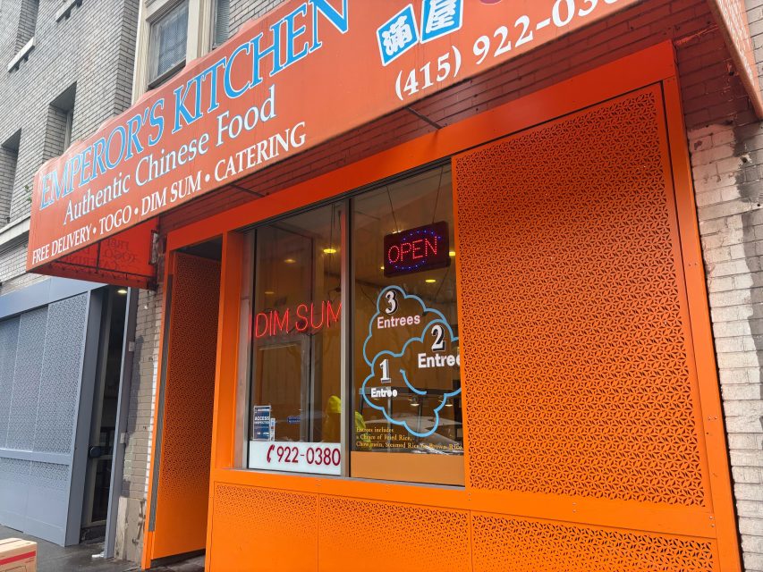 Orange storefront of Emperor's Kitchen, a Chinese restaurant offering dim sum, entrees, and takeout, with a neon "OPEN" sign and phone number displayed in the window.