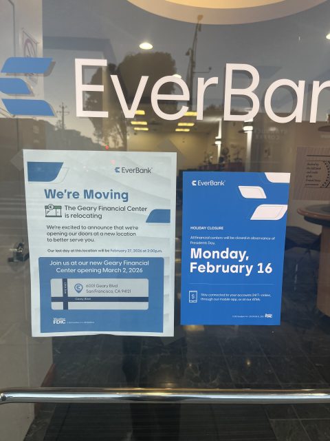 Two signs on a glass door announce EverBankโs relocation to a new address in March 2026 and a holiday closure on Monday, February 16.