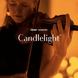 A person plays the violin in warm ambient lighting with the text "fever presents Candlelight" overlaid on the image.