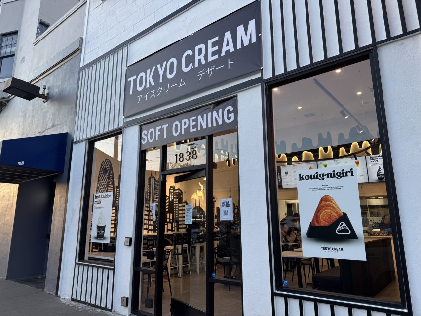 Street view of Tokyo Cream dessert shop with a "Soft Opening" sign and a poster advertising "kouig-nigiri" in the window.