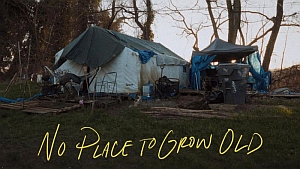 A worn tent and tarps set up in a wooded outdoor area, surrounded by debris and supplies. Text over the image reads, "No Place to Grow Old.