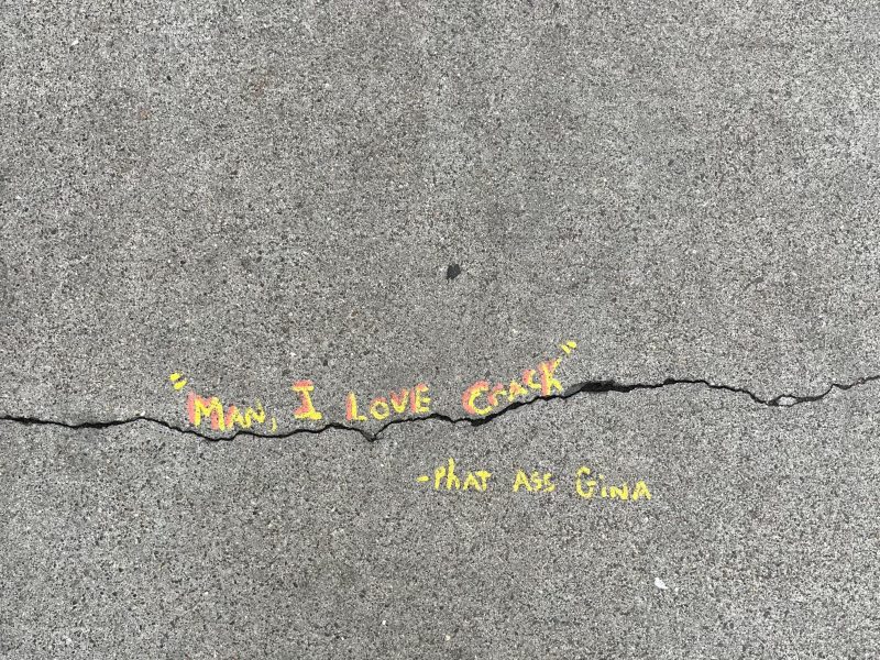 A crack in concrete with yellow text reading, "Man, I love crack" —Phat Ass Gina.