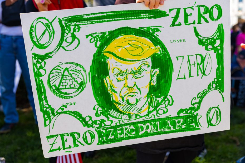 Hand-drawn protest sign resembling a dollar bill with a caricature of Donald Trump labeled “Zero Dollar” and the word “loser” written multiple times.