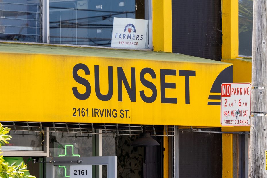 A yellow storefront sign reads "SUNSET 2161 IRVING ST." with a Farmers Insurance sign in the window above and a no parking street sign to the right.