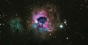 A mostly dark star field with a colorful nebula; the nebula contains an edited image of a man wearing sunglasses and a hat, superimposed in the center.