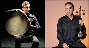 Two men in black shirts; one holds a large circular percussion instrument, the other holds a stringed instrument, seated against plain backgrounds.