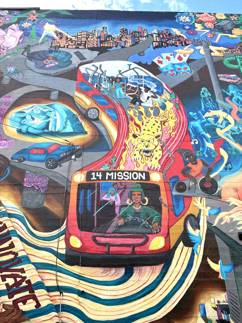 Colorful mural featuring a red city bus labeled "14 Mission," vibrant urban scenes, a tiger, city skyline, people, and surreal elements blending together on a large wall.