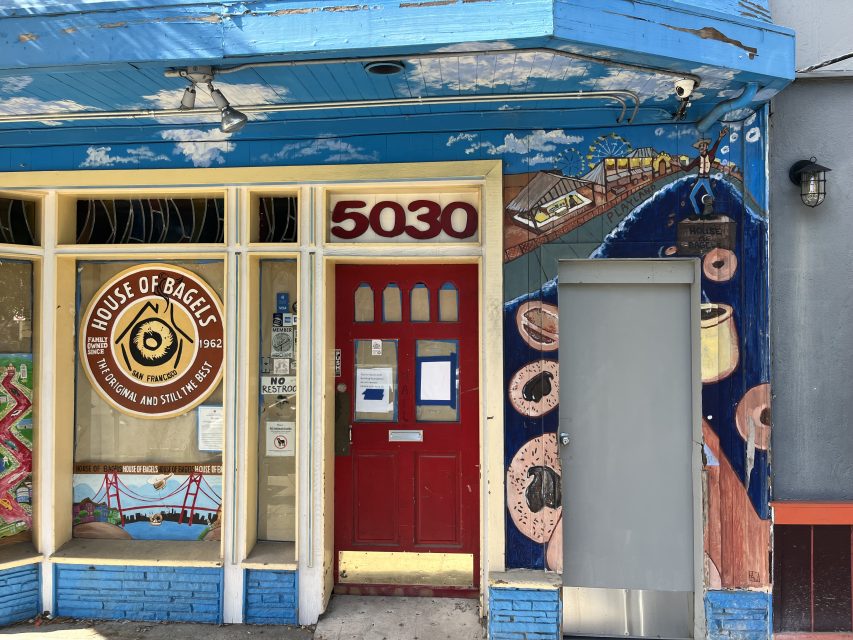 Storefront of House of Bagels at 5030 in Richmond, featuring a mural with bagels, coffee, and city landmarks on the exterior walls.