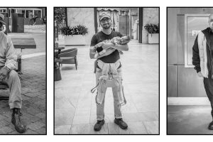 Three black-and-white portraits: an older man on a bench, a man holding a baby in a carrier, and a man standing indoors near a fire extinguisher.